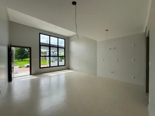 Sala ampla com grandes janelas e piso claro.