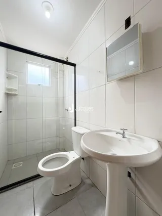 Foto de um banheiro com revestimento branco.