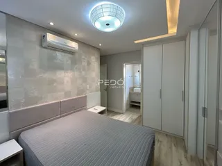 Quarto moderno com cabeceira e armários em um ambiente claro.
