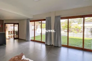 Sala de estar com portas de vidro que dão acesso a um gramado.