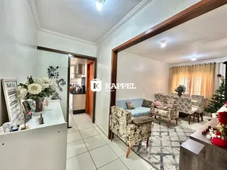 Foto de uma sala de estar com móveis e cortinas em um apartamento.