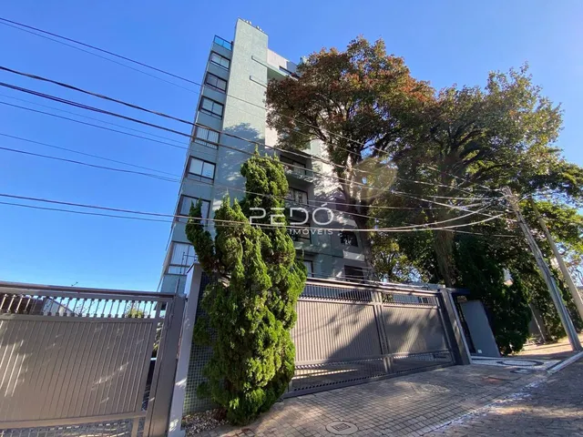 Fachada de um prédio residencial em Lajeado, Brasil, com vegetação ao redor.