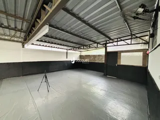 Imagem de um espaço interno com teto de metal e estrutura exposta.