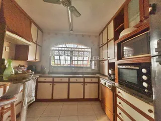 Foto de uma cozinha com armários de madeira e janela em Lajeado, Brasil.