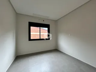 Ambiente interno de uma sala com janela de tijolos expostos.