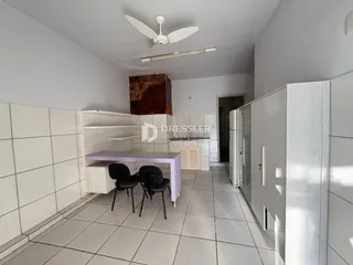 Interior de um ambiente com piso de cerâmica e armários brancos.