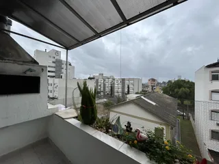 Vista de um terraço com vegetação e vista para edifícios ao fundo.