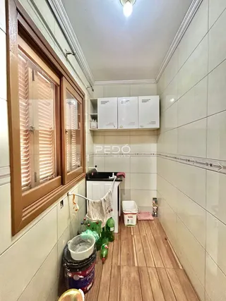 Hall de corredor com piso de madeira e paredes brancas em uma residência.