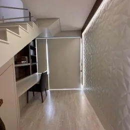 Vista de um corredor interno com paredes claras.