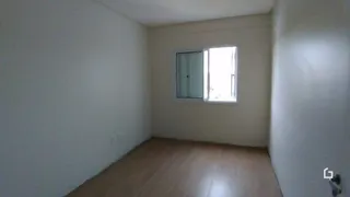 Interior de um cômodo com paredes brancas e piso de madeira clara.