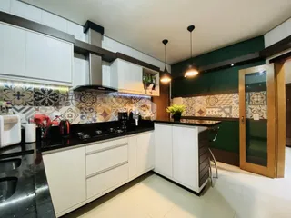 Cozinha moderna com armários brancos e bancadas escuras em Lajeado.