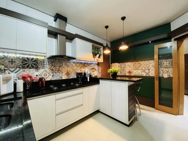 Cozinha moderna com armários brancos e bancadas escuras em Lajeado.
