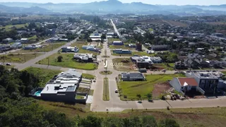 Vista aérea de uma área residencial em Lajeado, Brasil, mostrando casas e campos.