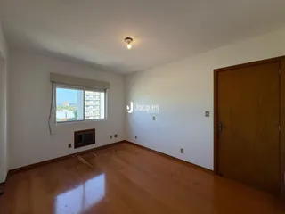Sala de estar com piso de madeira e janela com vista para a cidade.