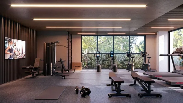 Foto de uma área de ginástica interna com equipamentos de treino.