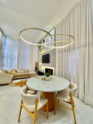 Sala de estar moderna com sofá e mesa redonda em ambiente claro.