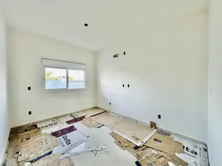 Foto de uma sala em reforma com o piso exposto.