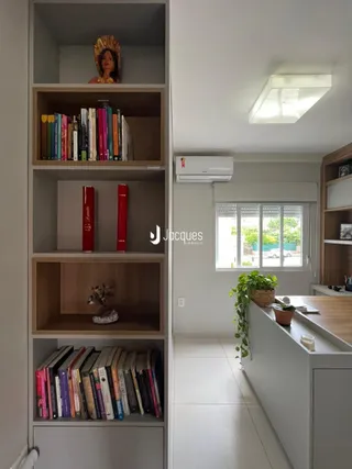 Prateleiras de madeira com livros em um ambiente interno.