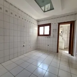 Foto de um corredor com piso e paredes brancas de cerâmica.