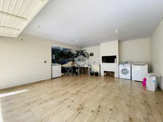 Ambiente interno amplo com piso de cerâmica e parede branca.