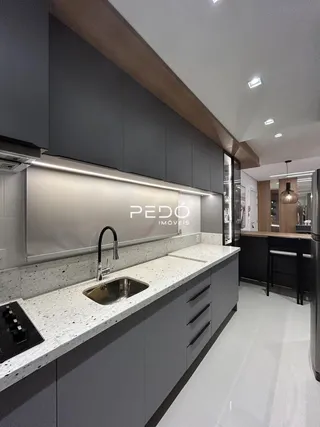 Cozinha moderna com armários cinzas e bancada clara.