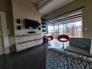 Sala de estar com parede de textura e porta de vidro que oferece vista da cidade.
