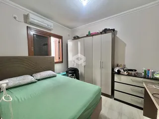 Quarto com cama e guarda-roupa em ambiente claro.