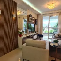 Sala de estar moderna com sofá e grandes janelas de vidro.