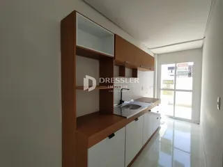 Vista de uma cozinha com armários de madeira e bancada clara.