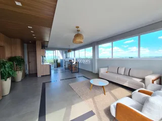 Sala de estar ampla com grandes janelas e vista para a paisagem.