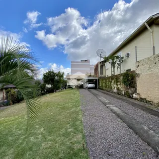 Vista externa de uma propriedade em Lajeado, Brasil, com jardim e entrada pavimentada.