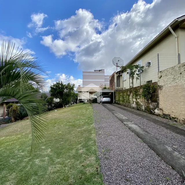 Vista externa de uma propriedade em Lajeado, Brasil, com jardim e entrada pavimentada.