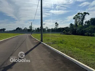 Uma vista de uma estrada que se curva por um campo gramado.