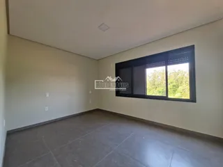 Ambiente interno de uma sala com paredes brancas e piso de cerâmica.