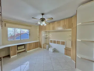 Sala de estar com armários planejados e piso de cerâmica em imóvel no Brasil.