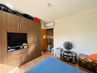 Quarto com armários de madeira e cama no interior de uma residência.