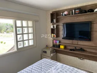 Quarto com janela e cabeceira de madeira.