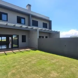 Fachada externa de um prédio residencial em Lajeado, Brasil, com gramado em primeiro plano.