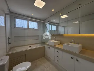 Foto de um banheiro moderno com revestimento branco e bancadas claras.