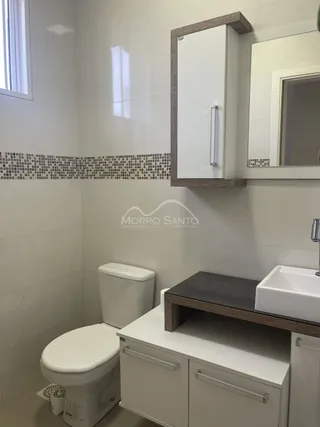 Foto de um banheiro com vaso sanitário e bancada.