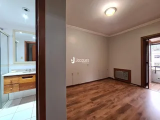 A sala apresenta piso de madeira e paredes brancas em um imóvel em Lajeado.