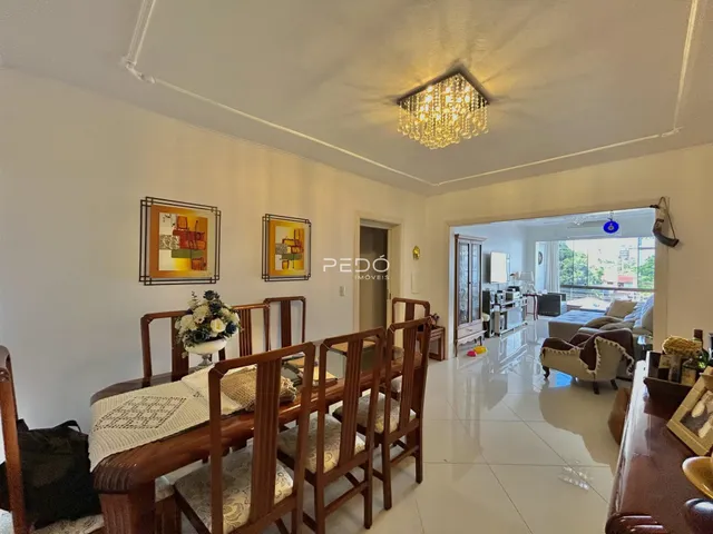 Uma sala de jantar com mesa de madeira e cadeiras em um imóvel no Brasil.