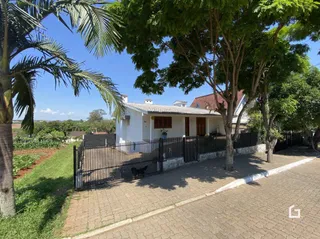 Fachada de uma casa em Lajeado, Brasil com cerca e jardim na frente.