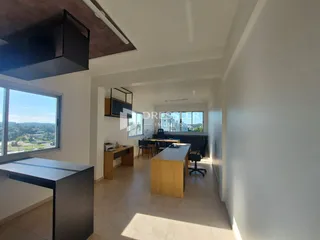Interior de uma sala de estar com vista para a paisagem externa.