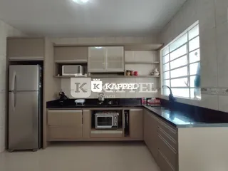Cozinha com armários superiores e inferiores e bancadas escuras.