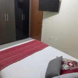 Foto de um quarto com cama de casal e roupa de cama vermelha.
