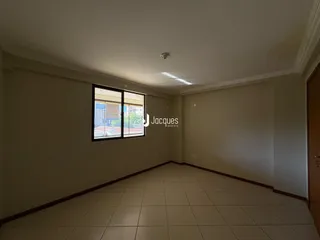 Vista interna de um corredor com piso de cerâmica claro e janela.