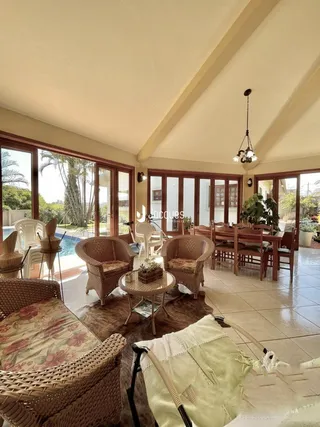 Sala de estar com móveis de vime e piso de cerâmica.