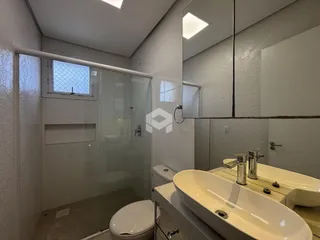 Banheiro moderno com box de vidro e pia de apoio
