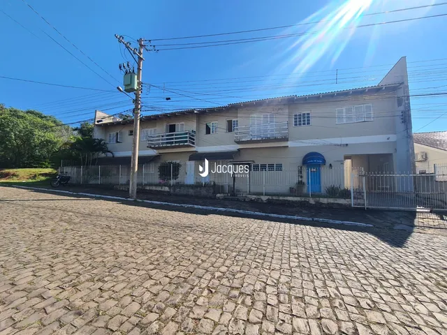 Fachada de uma casa em Lajeado, Brasil, com cerca e calçada de paralelepípedos.